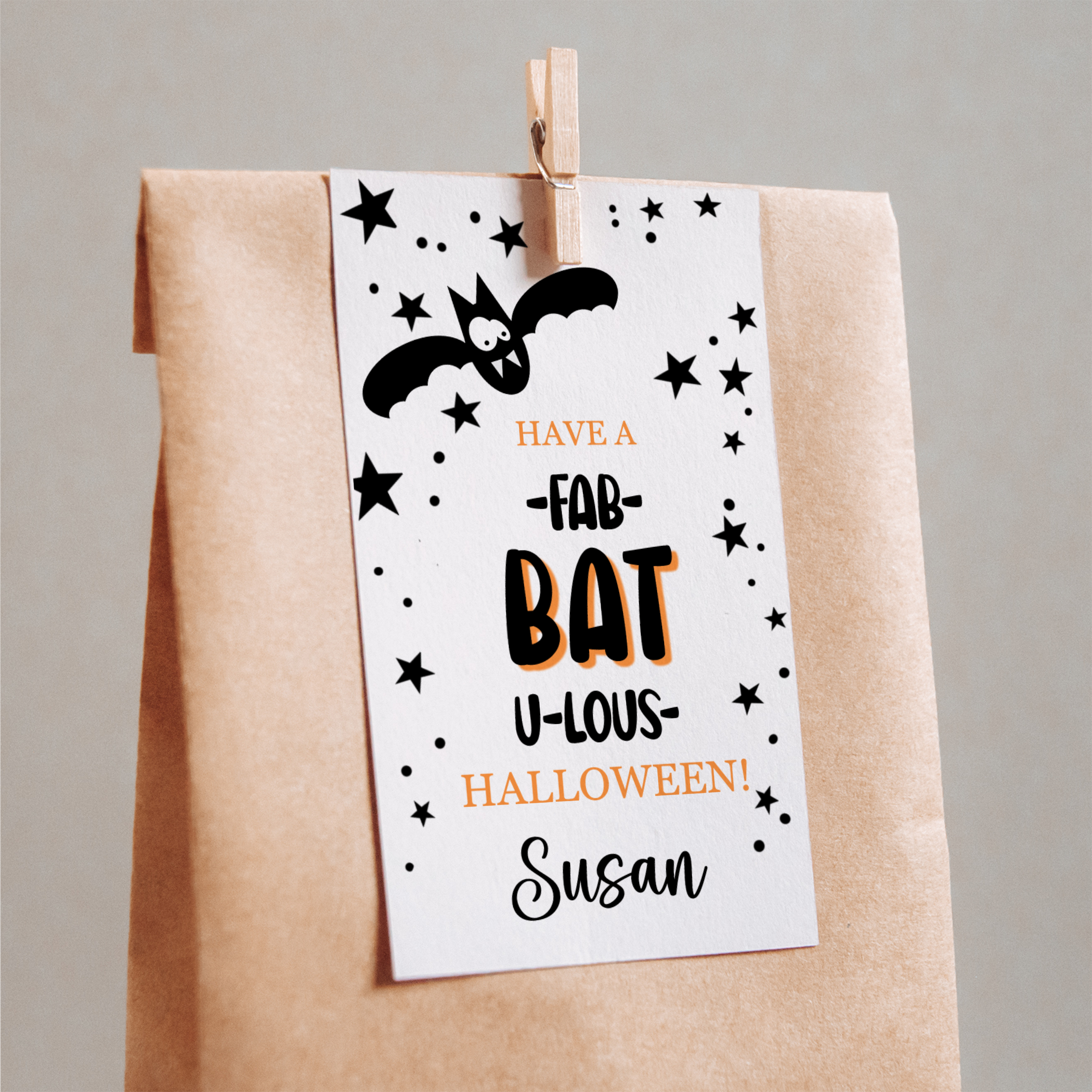 Halloween-themed gift bag with a decorative tag featuring a bat and text.