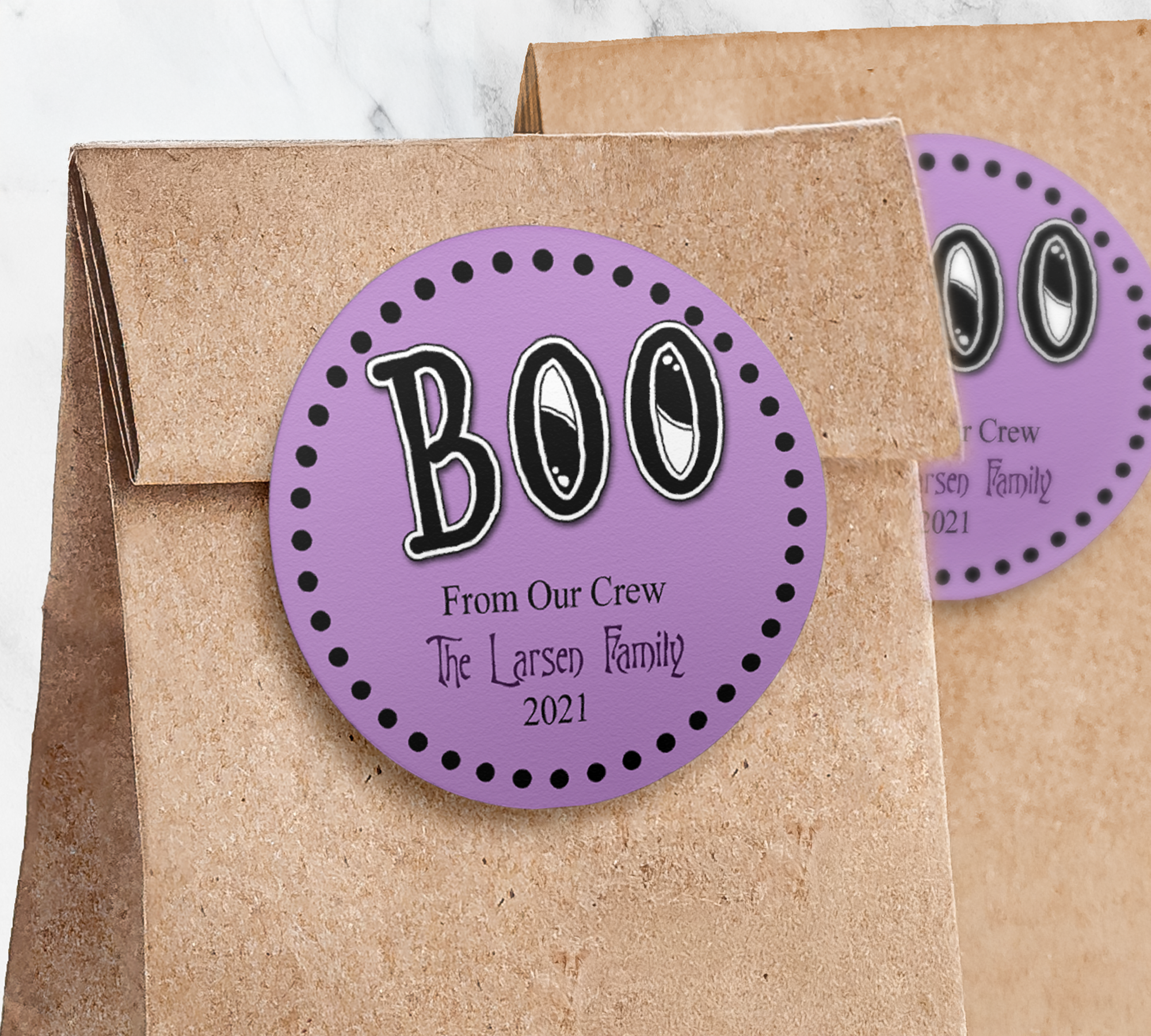 Round light purple sticker with black BOO on paper trick or treat bag